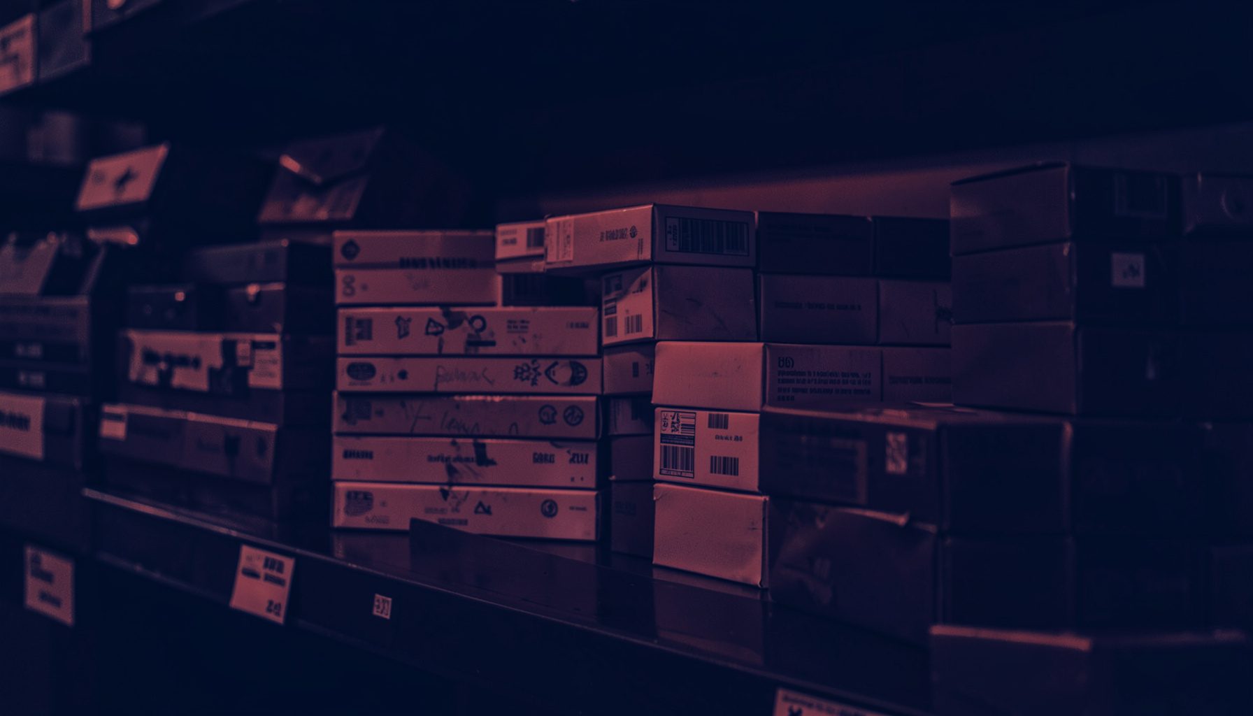 A dark atmospheric duotone photograph of stacked cigarette cartons on a warehouse shelf, deep navy blue and muted crimson tones, moody and commercial